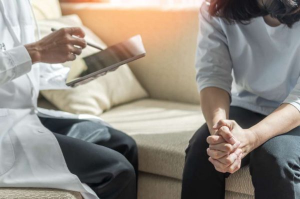 mujer con Trastorno de estrés postraumático complejo en consulta médica